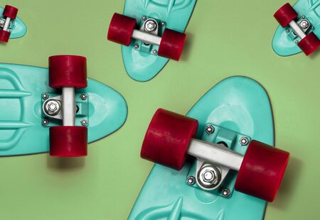 Turquoise Skateboards on green background, top view. Concept of sport lifestyle, culture, leisure,...