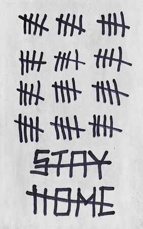 Crossed out Inscription Stay Home and signs tally marks counting the days on gray wall. Concept of isolation, quarantine and end of the pandemic coronavirus COVID-19の写真素材