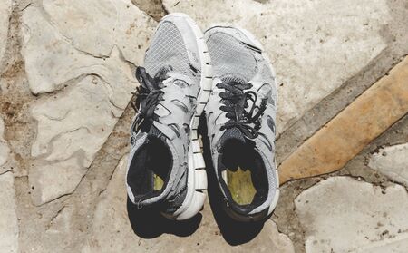 Old Running Shoes On Stone Surfaceの写真素材