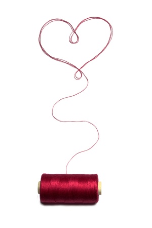 Heart made of red thread with spool の写真素材