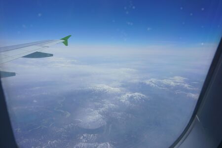 VIew of snow capped mountains from an airplane windowの写真素材