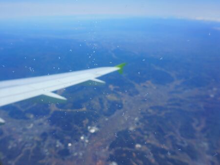 Snowflakes on the window glass. Airplane view of scenery and wing. Defocus backgroundの写真素材