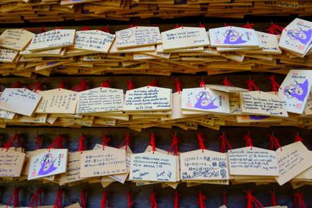 Kamakura / Japan - Sept 09, 2019: Hase-dera temple. Writing a wish on a small wooden plaque Ema and...