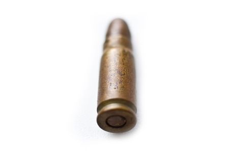 bullet on white, 9mm silver tipped bullet closeup on white, highkey and processed high-contrastの写真素材