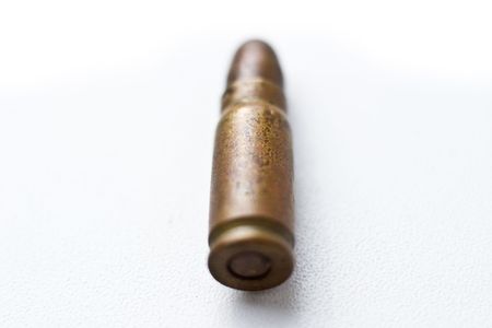 bullet on white, 9mm silver tipped bullet closeup on white, highkey and processed high-contrastの写真素材