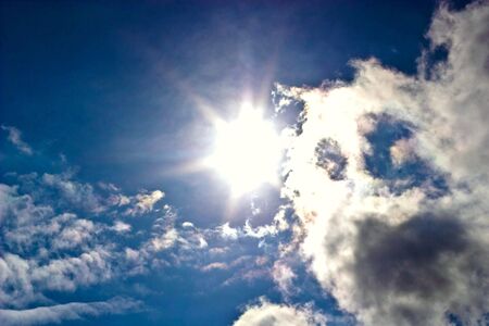 occurring yellow sun behind the clouds on a warm evening の写真素材