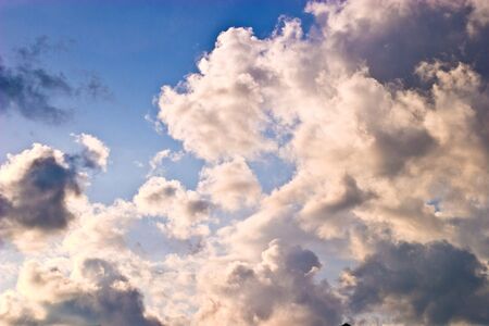 occurring sun behind the blue clouds on a warm eveningの写真素材
