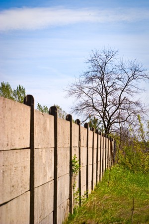 Old concrete boundary fence with nails on sunny day
の写真素材