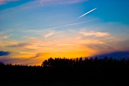 occurring yellow sun behind the clouds on a warm evening の写真素材