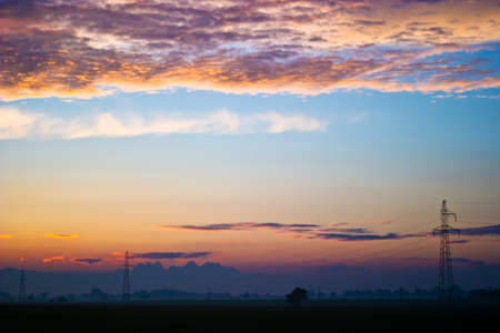 occurring yellow sun behind the clouds on a warm evening の写真素材