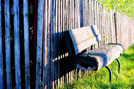Old wooden boundary fence with nails on sunny dayの写真素材