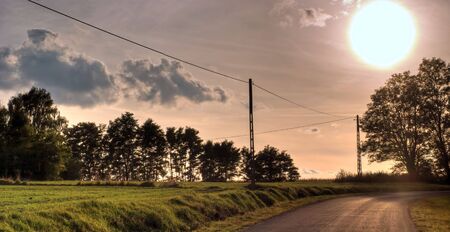 occurring yellow sun behind the clouds on a warm eveningの写真素材