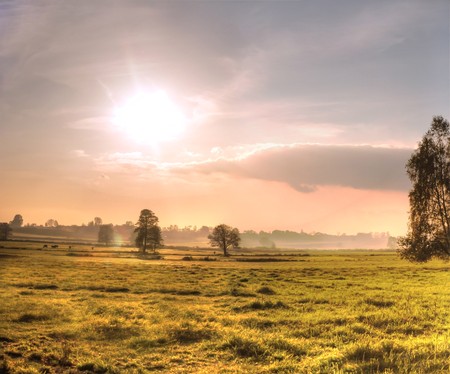 occurring yellow sun behind the clouds on a warm eveningの写真素材