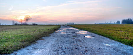 road, ground road under fluffy clouds, fall scenic roadの写真素材