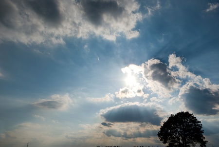 occurring yellow sun behind the clouds on a warm eveningの写真素材