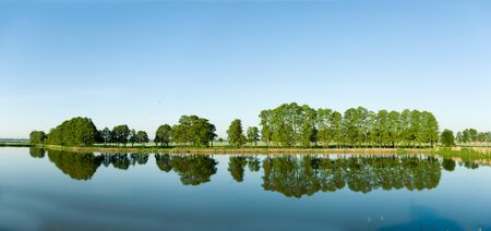 A rural small lake and a green forestの写真素材
