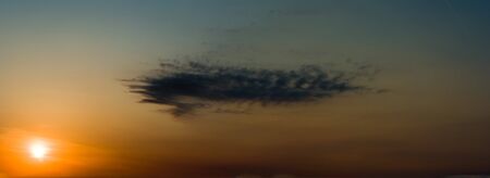 occurring yellow sun behind the clouds on a warm evening