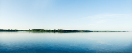 A rural blue lake and a green forestの写真素材