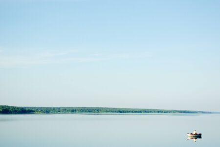 A rural blue lake and a green forestの写真素材