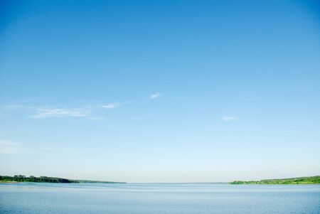 A rural blue lake and a green forestの写真素材