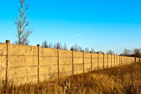 Old wooden boundary fence with nails on sunny dayの写真素材
