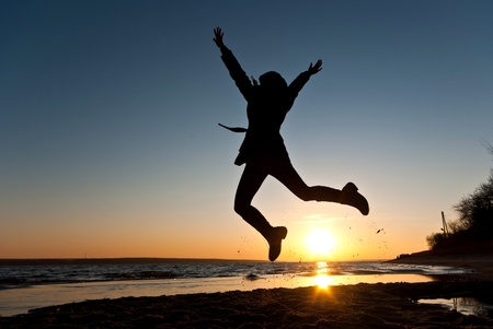 person jump near blue lake with cloudy sky, nature seriesの写真素材