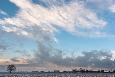 occurring yellow sun behind the clouds on a cold eveningの写真素材