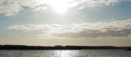 occurring yellow sun behind the clouds on a warm eveningの写真素材