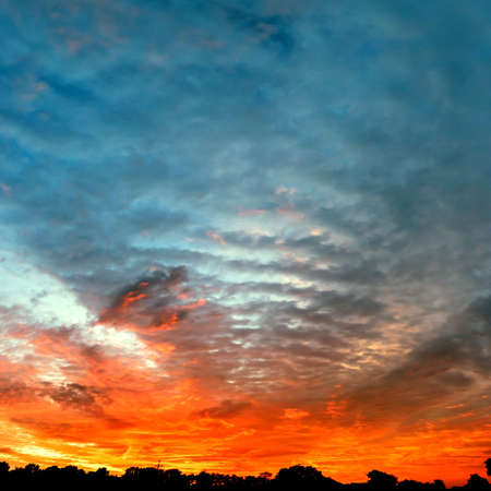 occurring yellow sun behind the clouds on a warm eveningの写真素材