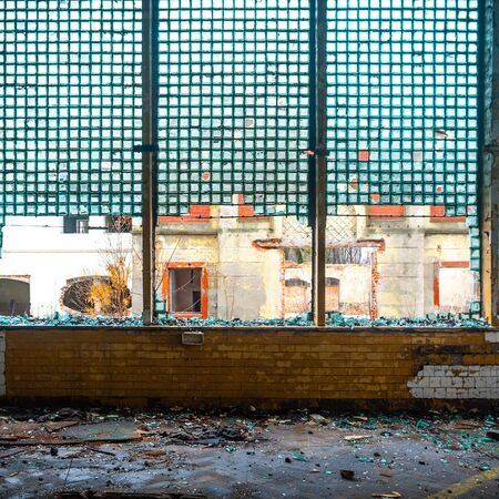 Discarded ruin with old windows and wall, industrial window in concrete wall