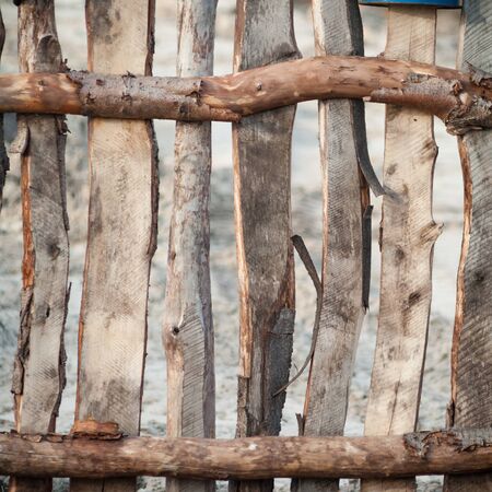 Old wooden boundary fence with nails on sunny dayの写真素材
