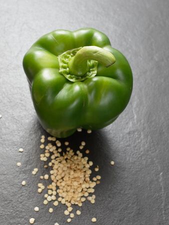 Seeds of bell pepper or capsicum with green bell pepper over dark backgroundの写真素材