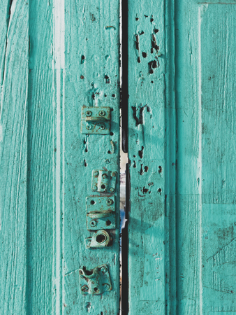 Colorful wooden door surface with lock painted with green, blue, or aquamarine color in vintage and retro style, used as backgroundの写真素材