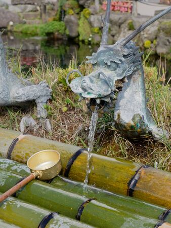 YAMANASHI, JAPAN - SEPTEMBER 26, 2017 : Spring water from dragon ornament tap of Waku pond is one of the main tourist attraction in Oshino Hakkai or springs of Mount Fuji, Oshino villageのeditorial素材