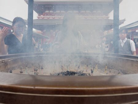 TOKYO, JAPAN - SEPTEMBER 28, 2017 : Gigantic bronze incense burner in front of Main Hall of Sensoji temple, Asakusa, where tourists bathing their hands and faces with incense smokeのeditorial素材