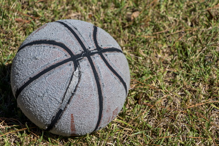 Worn out basketball sitting in the grass.の写真素材
