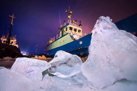 The Icebreaker ship trapped in ice tries to break and leave the bay between the glaciersの写真素材