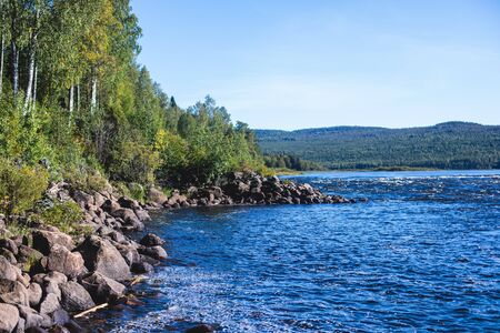 View of Kalix river, Kalixalven, Overkalix locality and the seat in Norrbotten county, Sweden, with forest in sunny summer day, aerial drone viewの写真素材