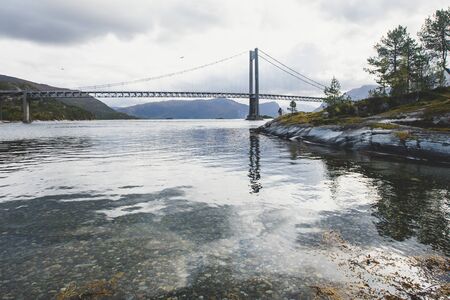 Classic Norwegian cold panoramic landscape of Efjorden fjord, Ballangen municipality, Nordland county, Ofoten district, Norway with Efjord Bridges, Stortinden mountain, Northern Norwayの写真素材
