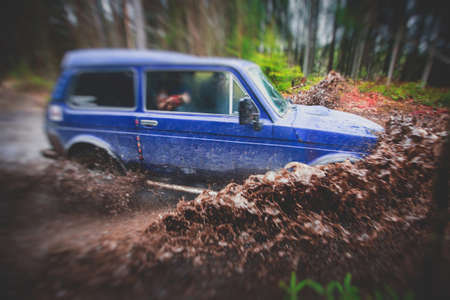 Suv offroad 4wd car rides through muddy puddle, off-road track road, with a big splash, during a jeeping competitionの写真素材