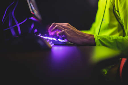 Cyber sport e-sports tournament, team of professional gamers, close-up on gamer's hands on a keyboard, pushing button, gamers playing in competitive moba / strategy fps game on a cyber games arena clubの写真素材