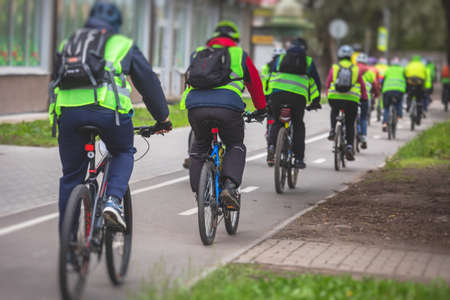 View of bicycle race in the city streets, bike race with a group mass of cyclist athletes in cycling competition, team of bikers on urban bike pathの写真素材