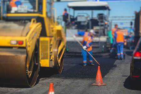 Process of asphalting and paving, asphalt paver machine and steam road roller during road...
