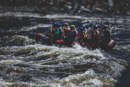 Raft boat during whitewater rafting extreme water sports on water rapids, kayaking and canoeing on a river, water sports team with a big splash of waterの写真素材