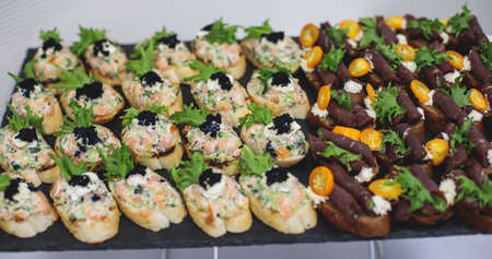 Catering table, beautifully decorated banquet with variety of with different food snacks and...