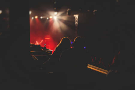 A crowded concert hall with scene stage lights, live show performance, with people silhouette, dance floor during a concert open-air festivalの写真素材