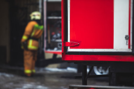 Group of fire men in uniform during fire fighting operation in the city streets, firefighters with...