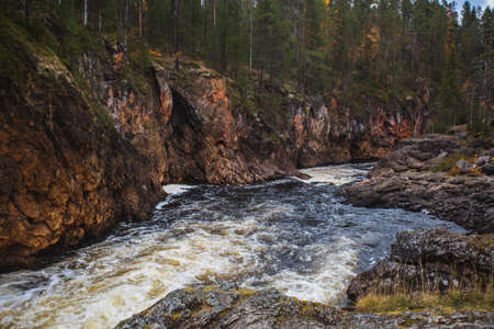 Autumn view of Oulanka National Park, landscape, a Finnish national park in the Northern Ostrobothnia and Lapland regions of Finland, wooden wilderness hut, cabin cottage, bridge, campgroundの写真素材
