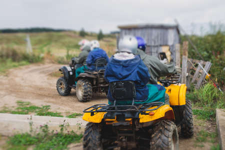 Group of riders riding atv vehicle on off road track, process of driving ATV vehicle, all terrain quad bike vehicle, during offroad competition, crossing mudの写真素材