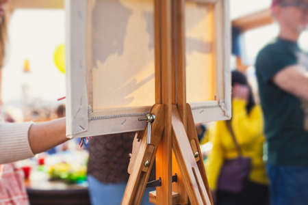 Process of painting, group class of adult talented students with paints easels, and canvases during lesson of watercolor painting outdoors, summer dayの写真素材